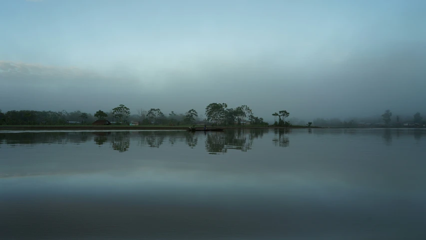 a view of a river during the day with clouds reflecting in it