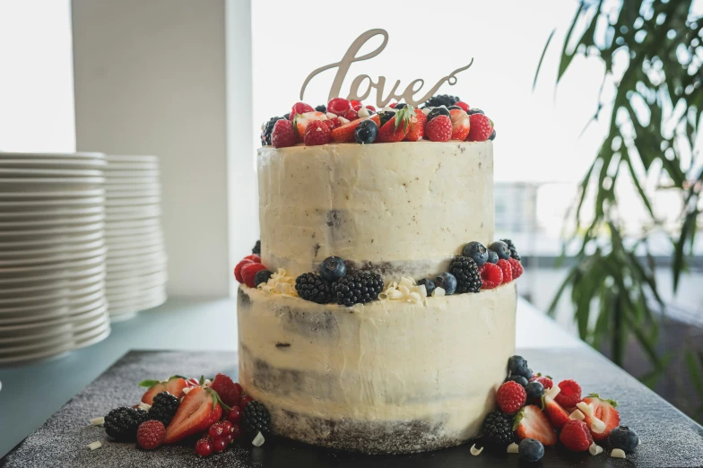 a cake with berries and blueberries on top is displayed