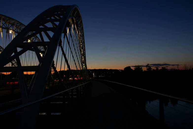 a bridge is silhouetted against a dusk sky