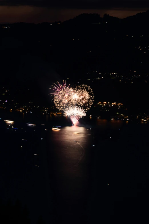 fireworks light up the sky at night over a body of water