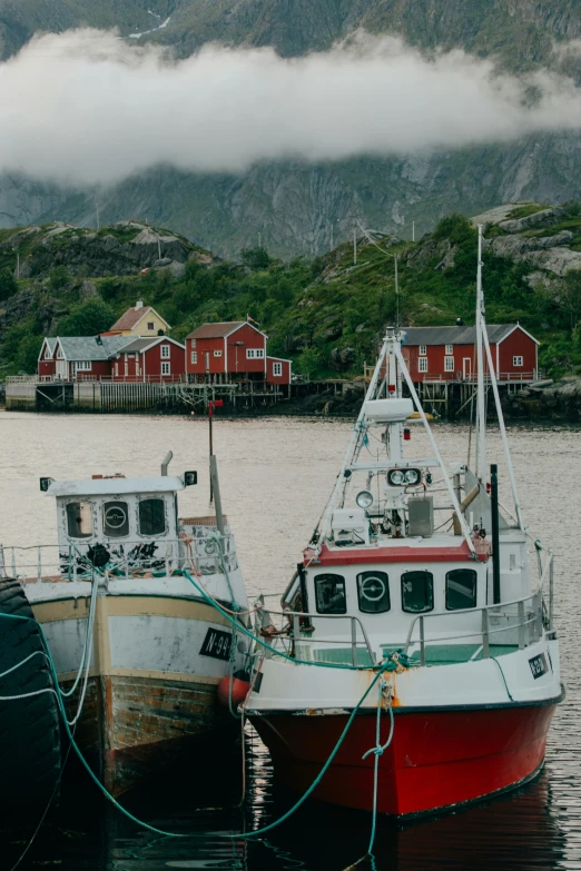 two fishing boats sit tied together in the water