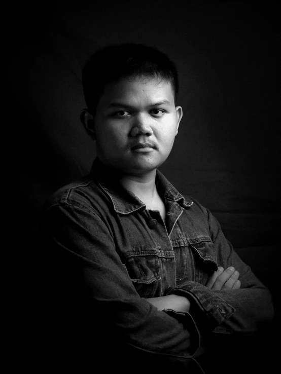 black and white pograph of a man in denim shirt with arms folded in front