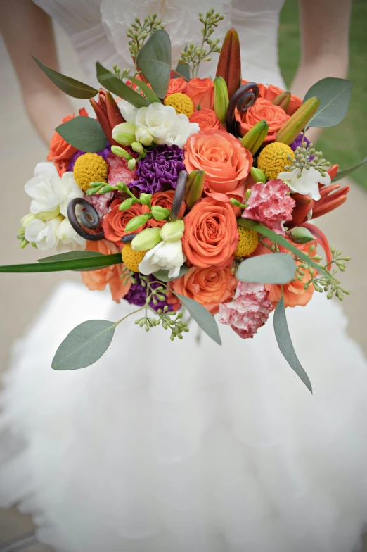 a bouquet of flowers sitting on top of a brides dress