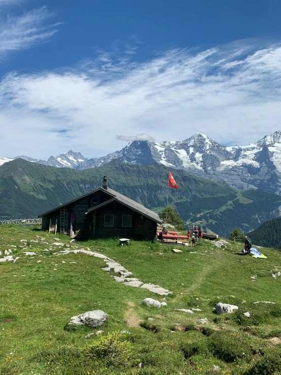 a lone wooden cabin on the side of a hill