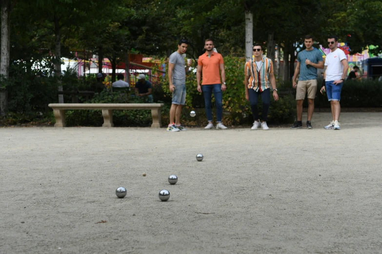 men are playing soccer outside by the bench