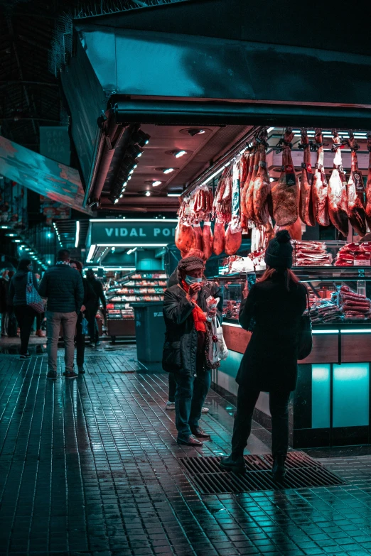 a market is lit by red lights and people walking