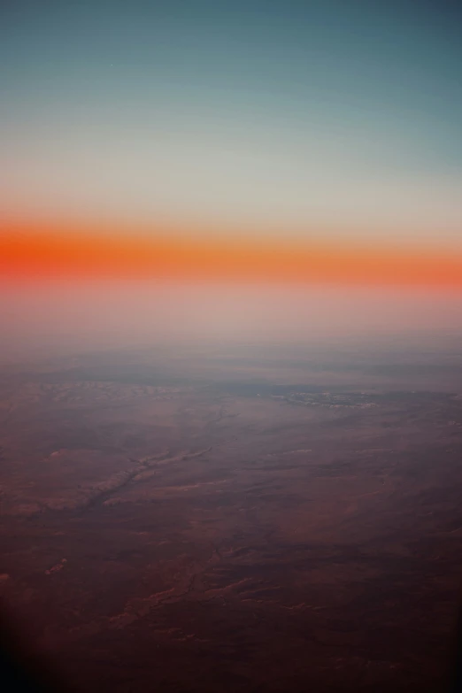 orange and blue colored clouds above in an airplane