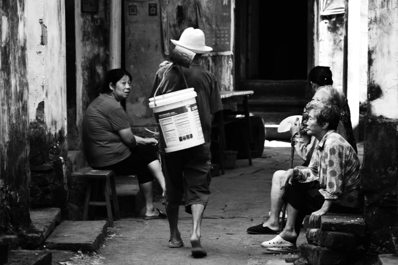 a group of people sitting in the street in black and white