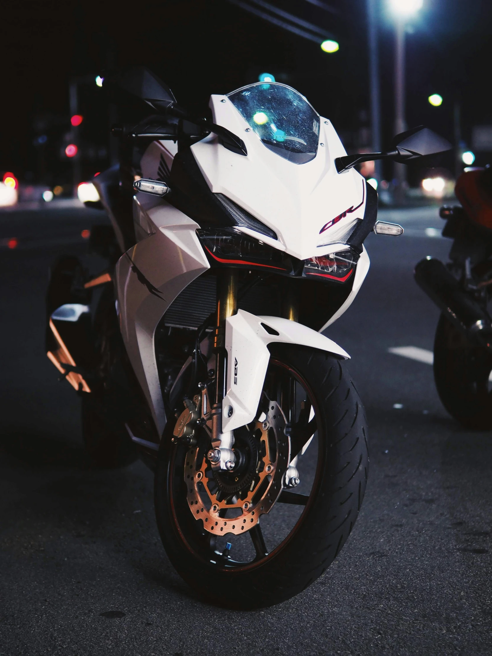 a white motorcycle parked next to a building at night