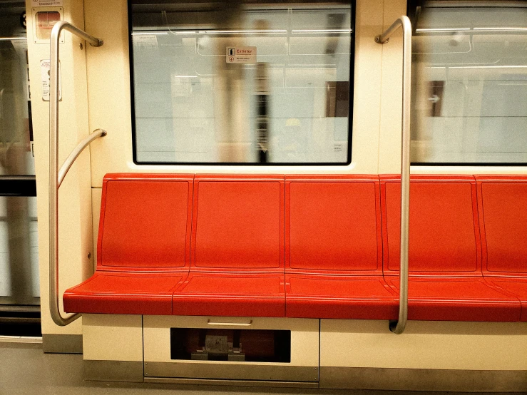 a train station with a row of red seats