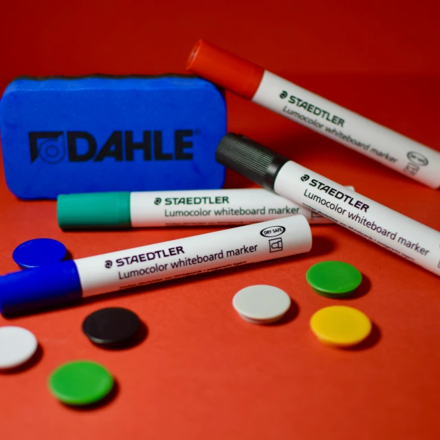 three markers, including two markers, are placed next to a bag of pills