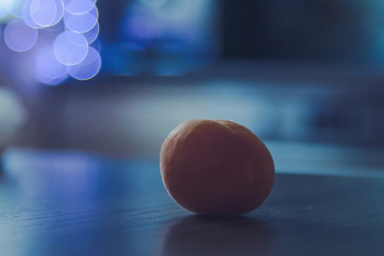 a whole orange sitting on a shiny table