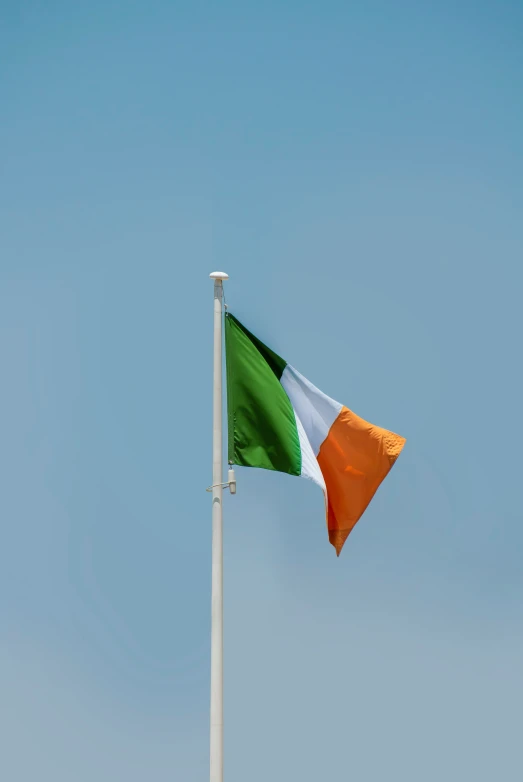 the flag of ireland is flying against the blue sky