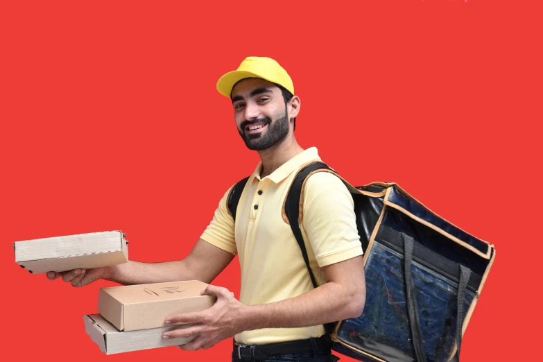 a man in yellow shirt with two cardboard boxes in hand