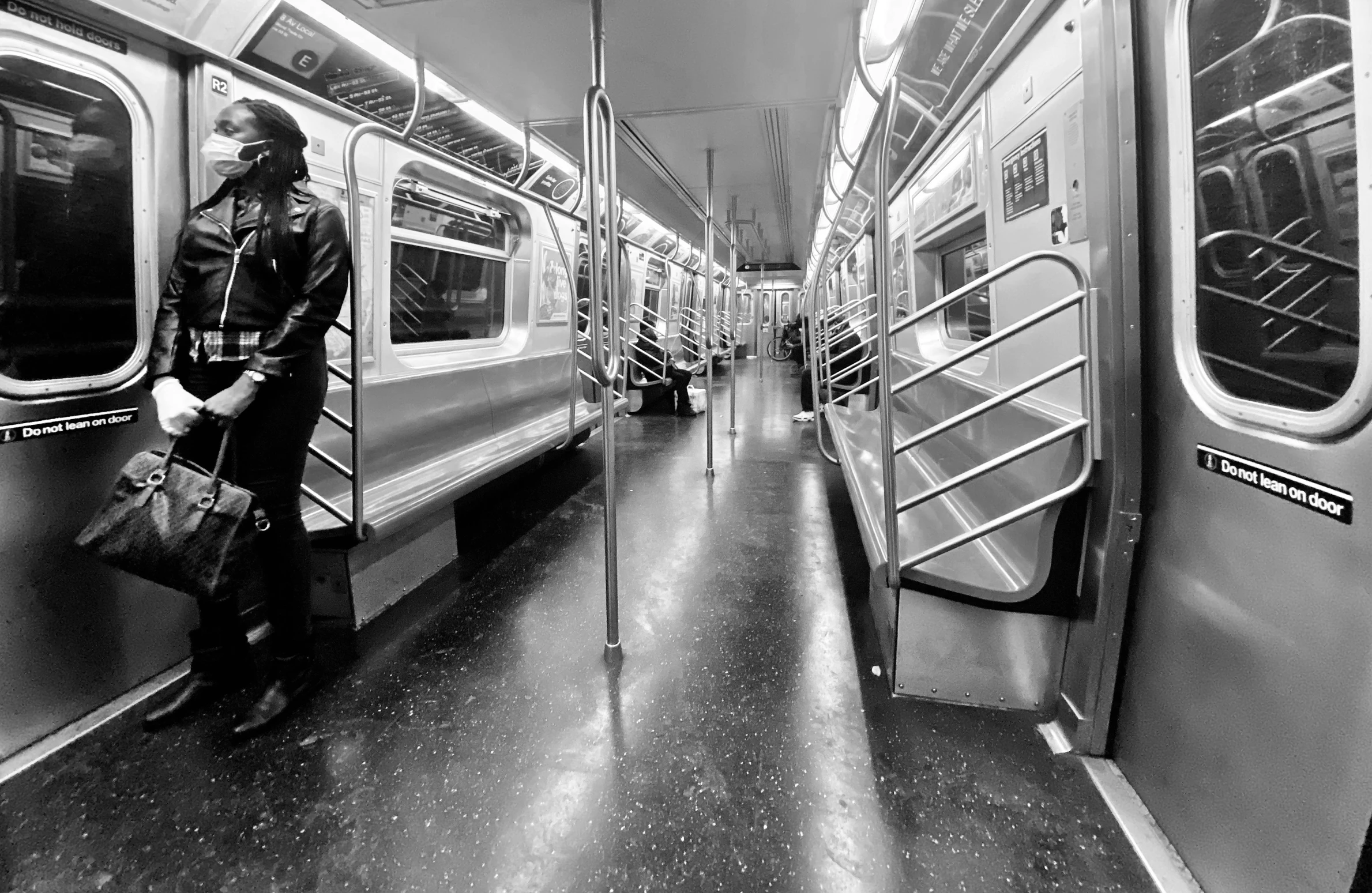 a man with a bag walks on the inside of a train