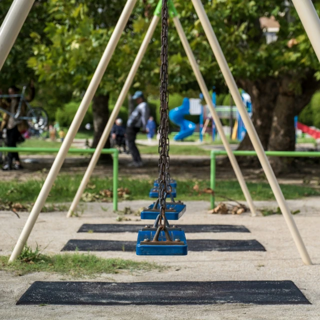 several children's swing seats hanging over a playground