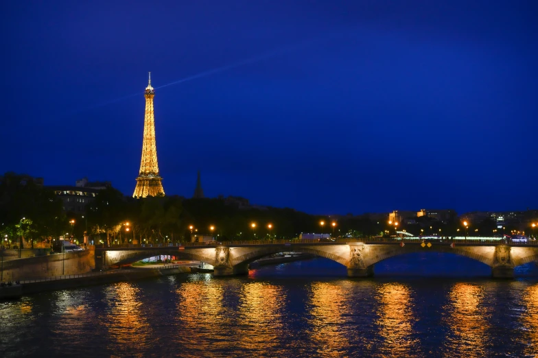 the view of the eiffel tower at night from across the river