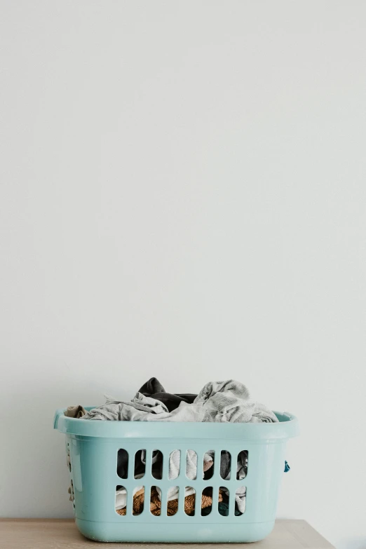 a blue laundry basket sitting on top of a table