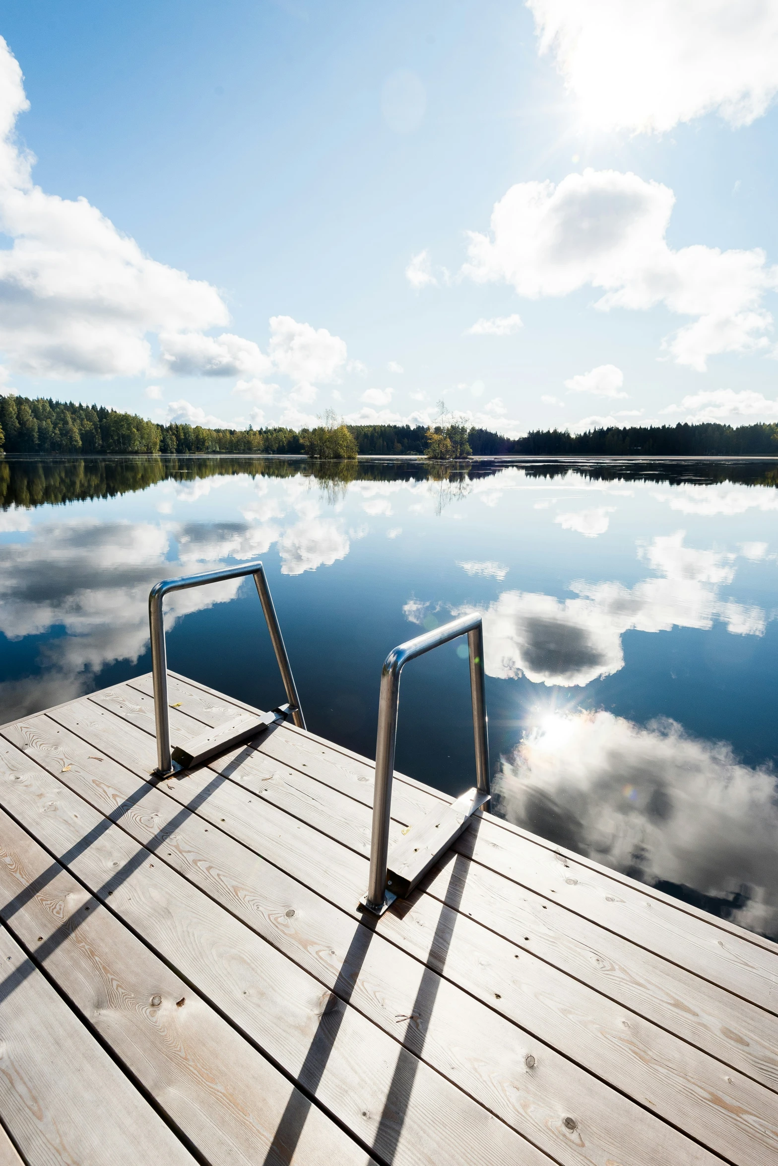 an empty dock overlooks a peaceful lake in the afternoon