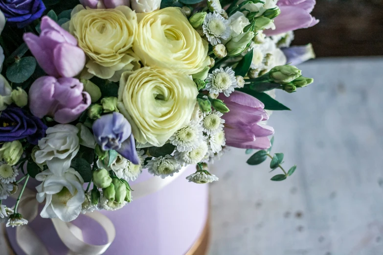 a bouquet of white, pink and purple flowers in a metal container