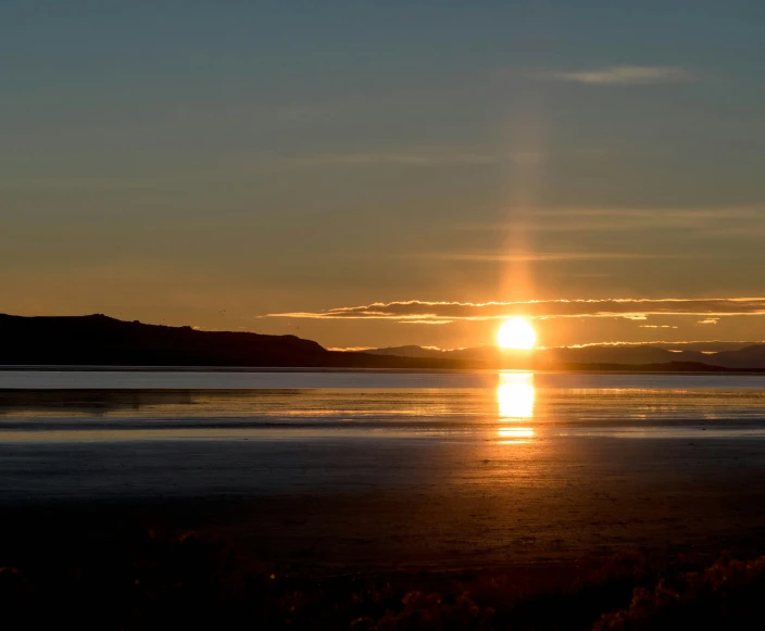 a sun set over water on the horizon