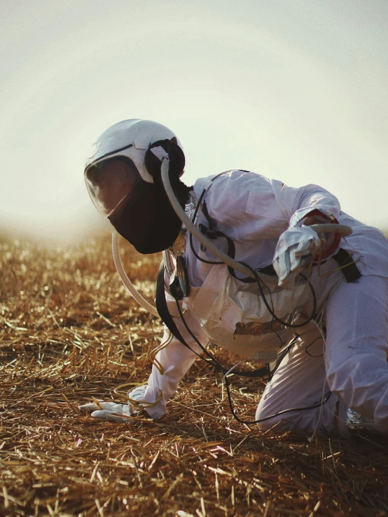 an astronaut is trying to climb down in the grass