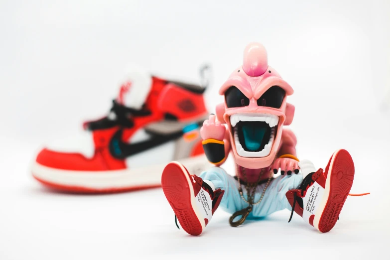 two sneakers, one in pink and red and the other red with black and white