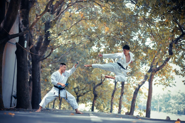 a young man doing karate on a city street