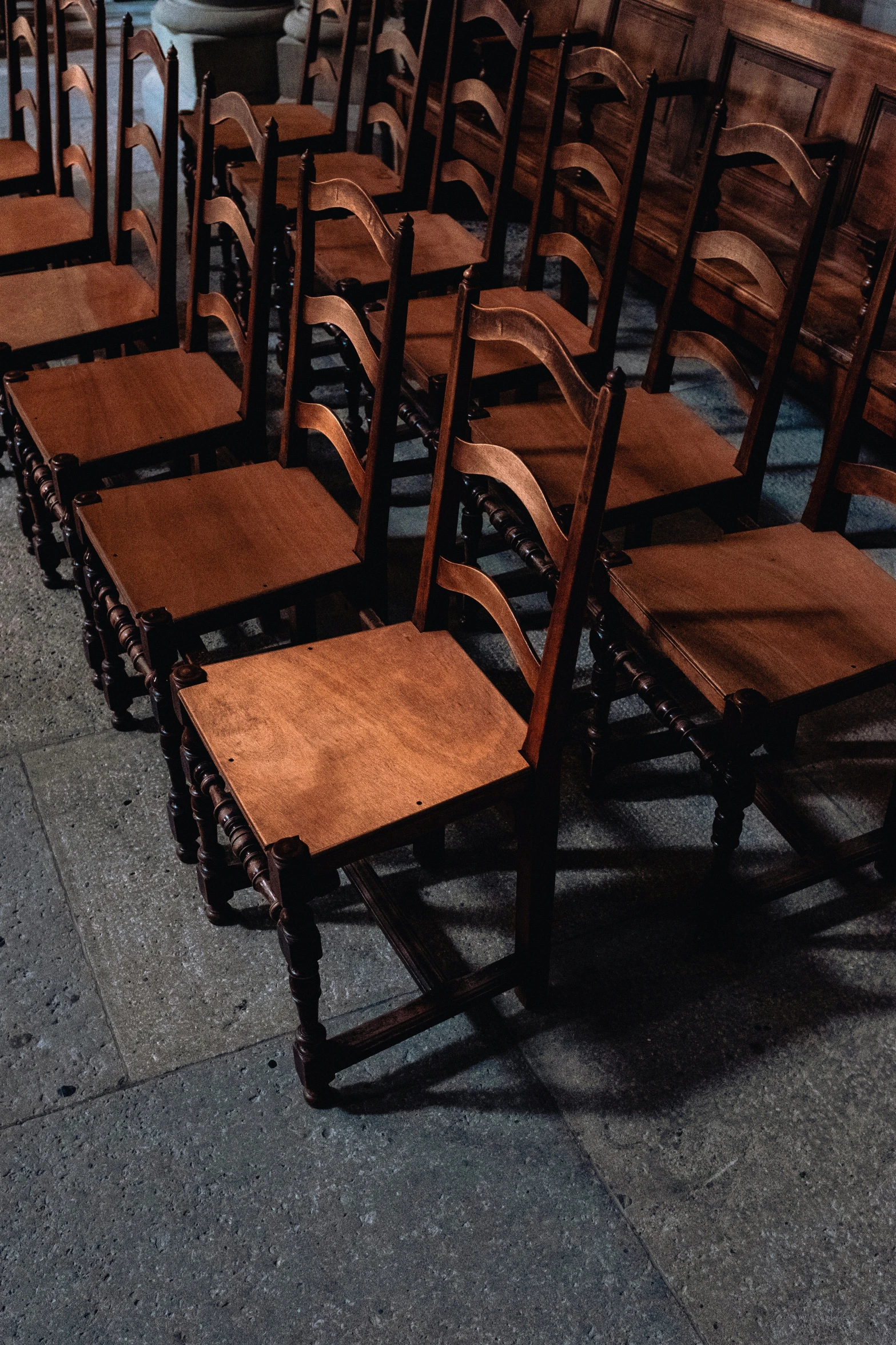 a set of eight wooden chairs sitting on the floor