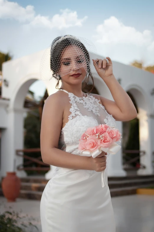 a bride looking at the camera with her veil dd over her head