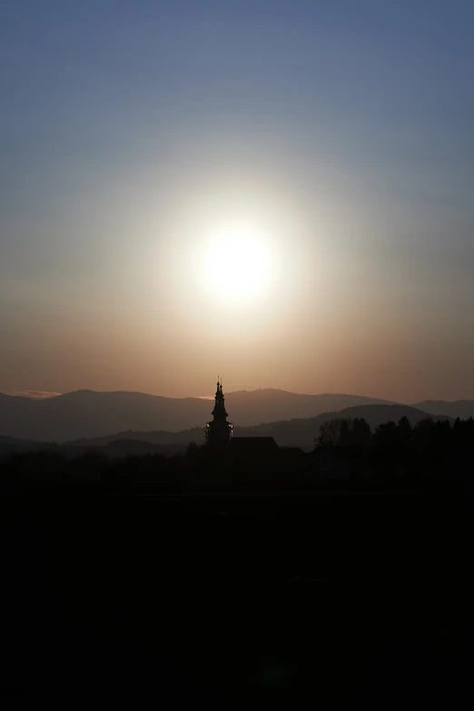 a small church spire sitting in the middle of the sun