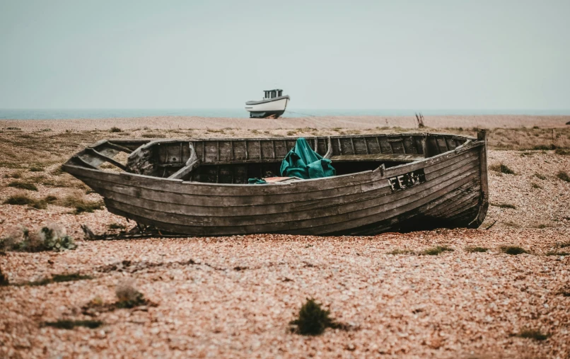 a boat laying on the beach near two water towers