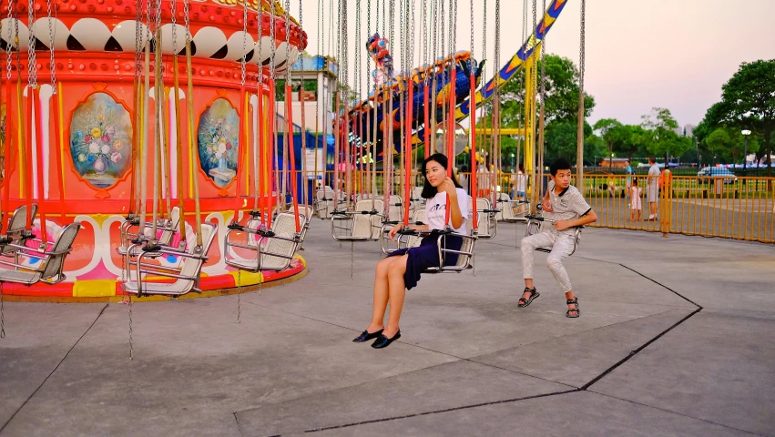 there is a girl on a swing ride at an amut park