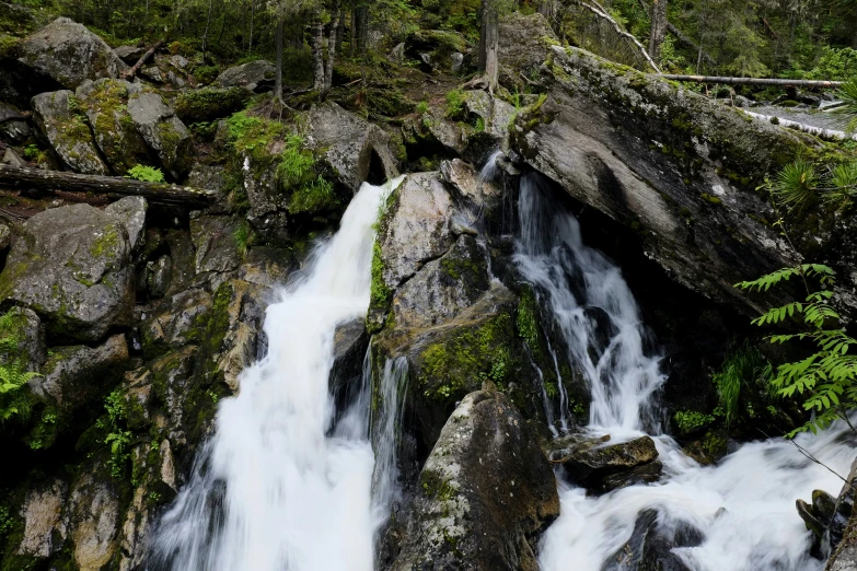 a group of large rocks next to a waterfall