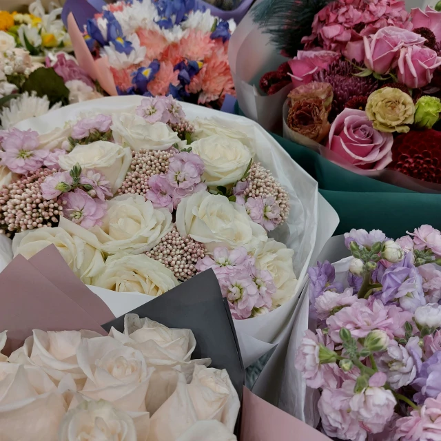 a variety of different colored flowers in bowls