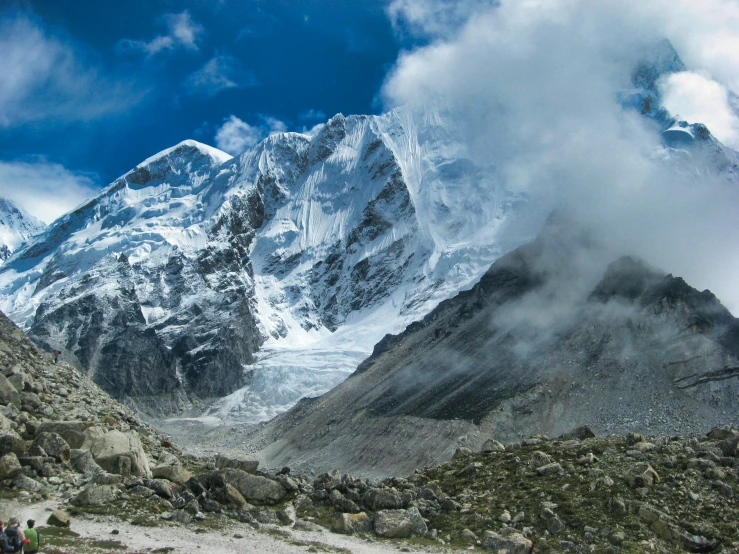 a couple of people walking on a rocky trail