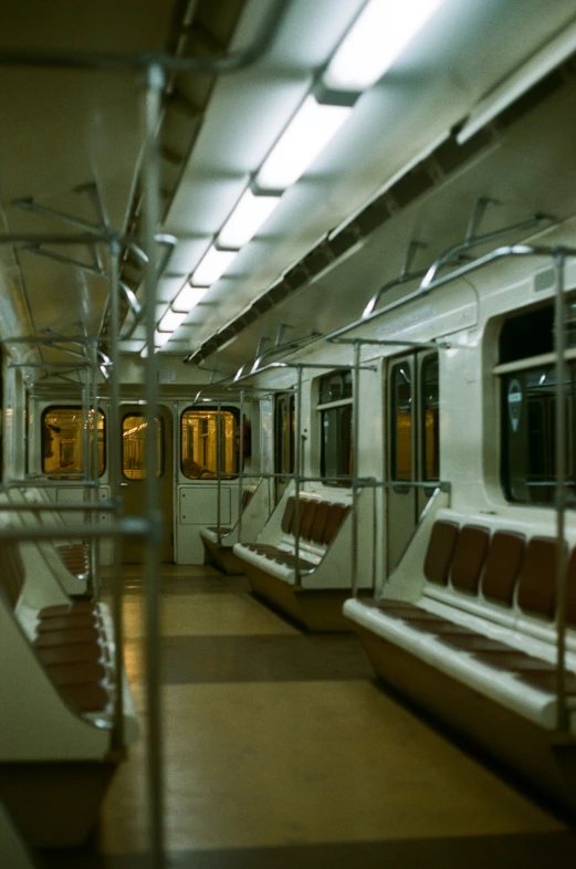 a train parked inside of a subway station with lots of seats