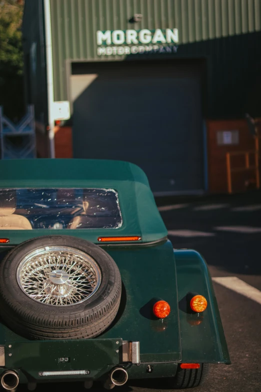 a green jeep with black tires and the top