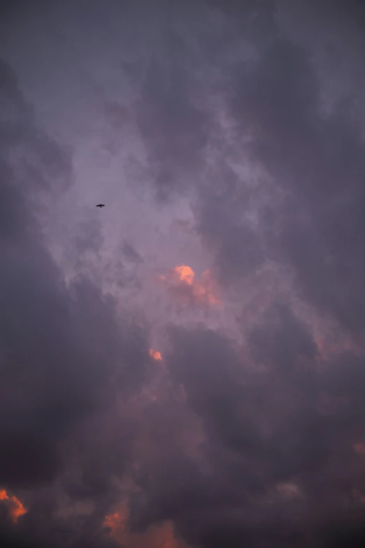 the silhouette of a plane in a purple sky