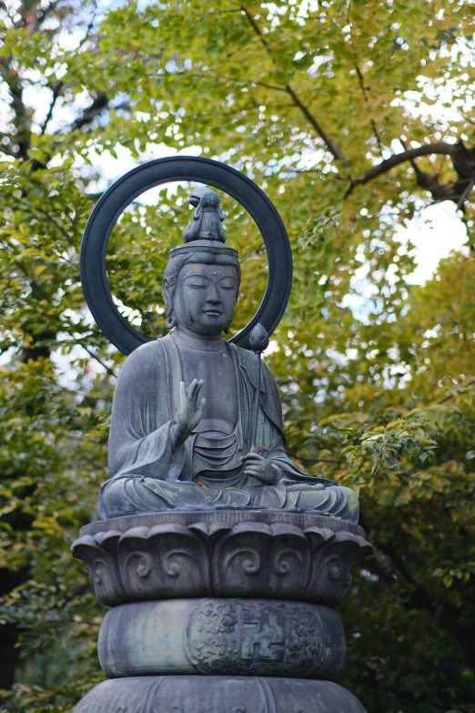 a close up of a statue of a person surrounded by trees