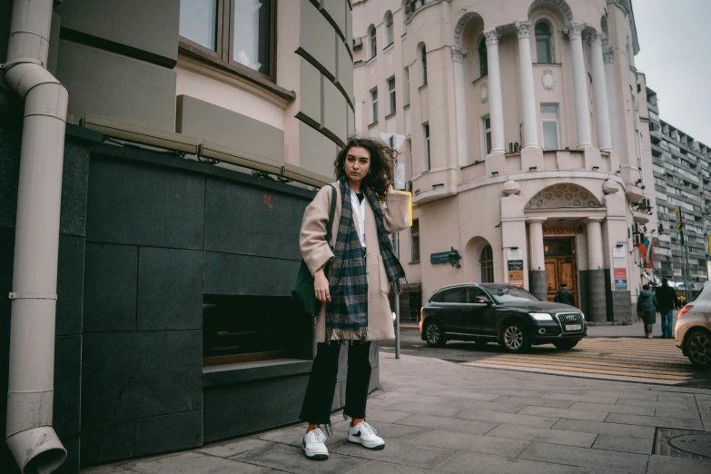 a person standing next to a building on the street