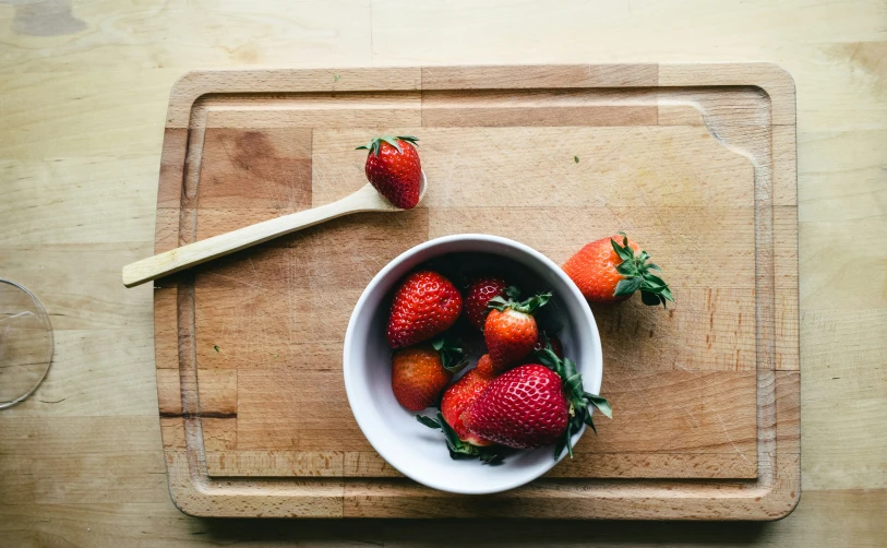 a bowl with a bunch of strawberries on a table