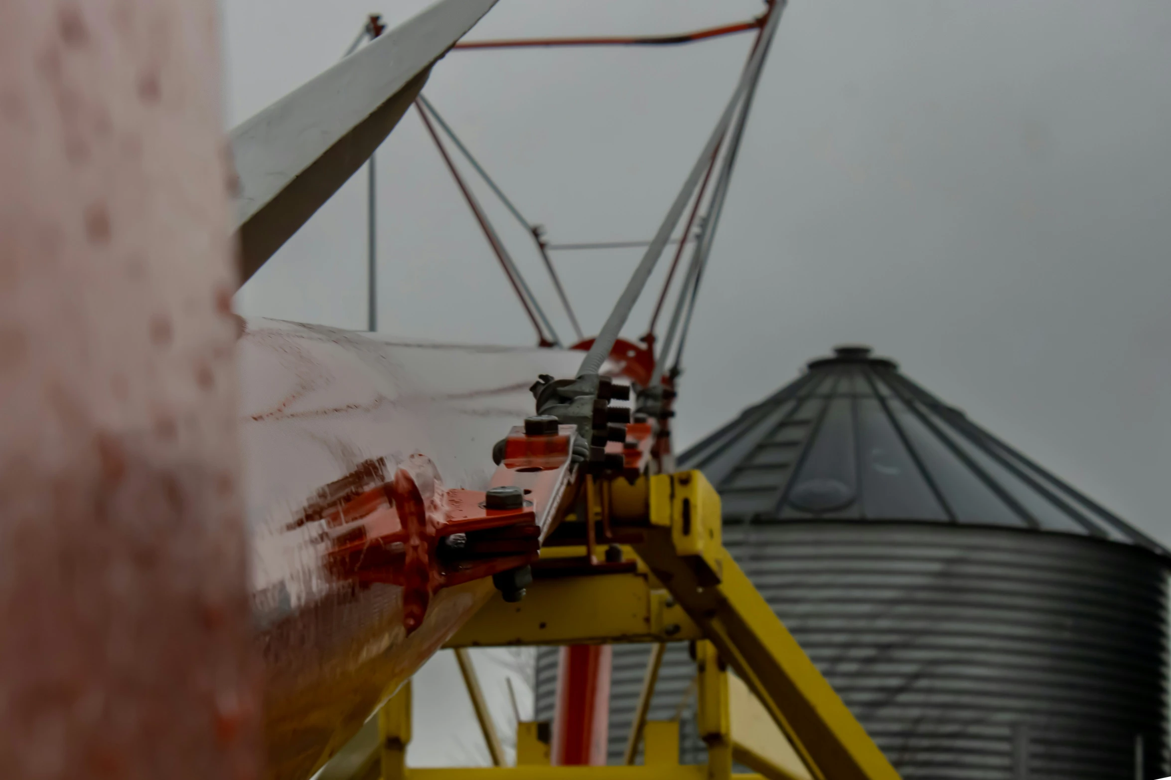 a metal crane holding some large oil tanks