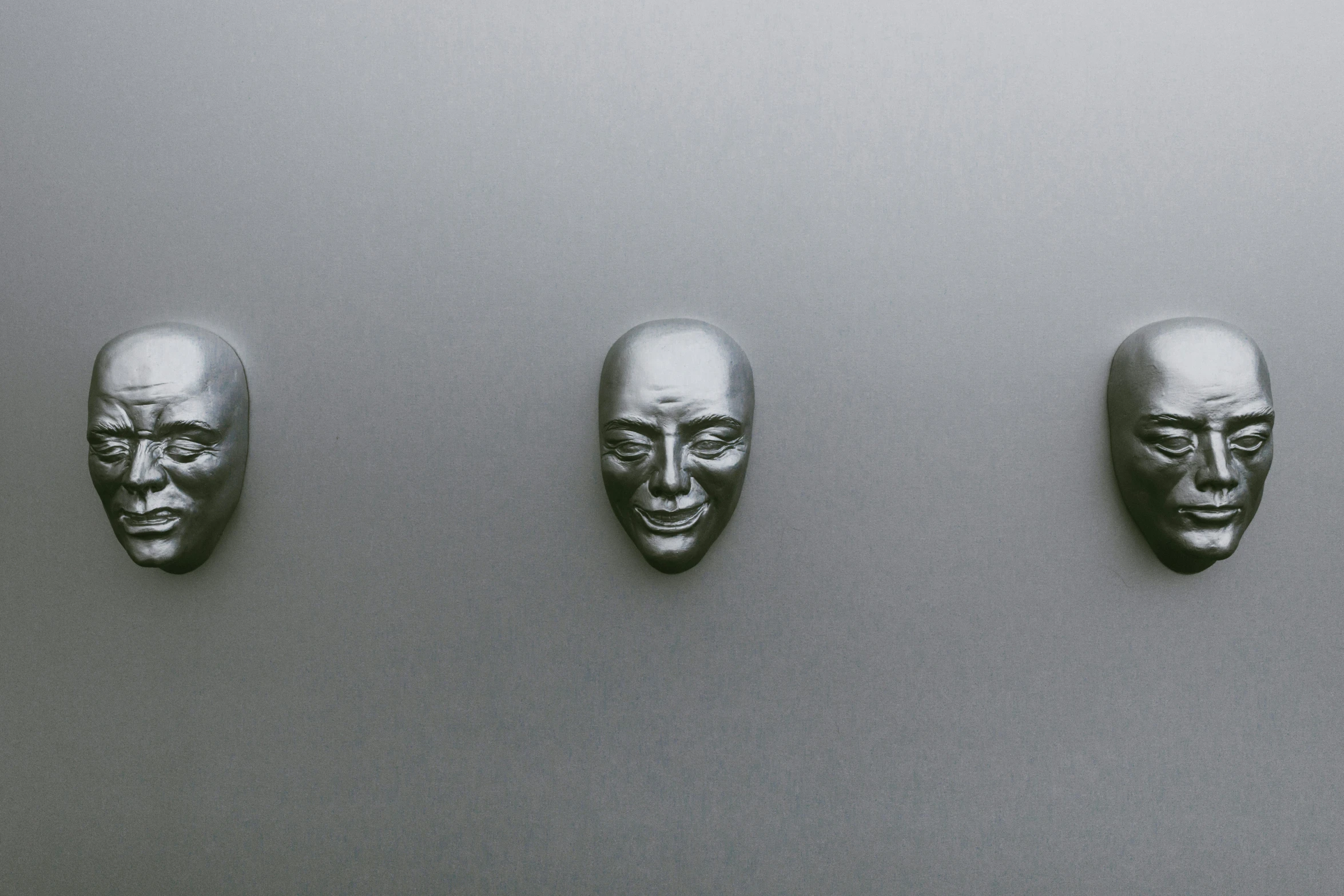 three small mask masks are placed on a white wall
