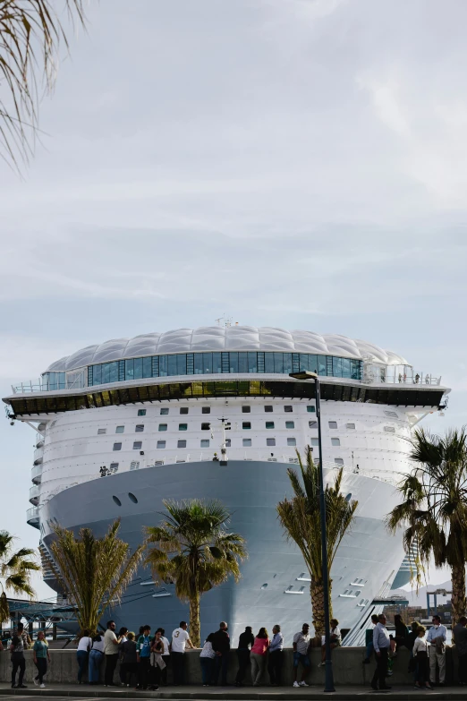 many people gather at the beach on a large ship