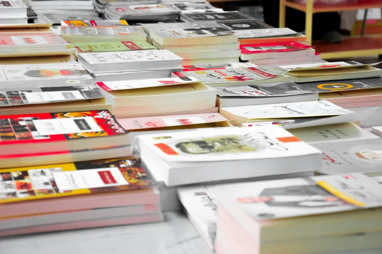 many books with designs on them are being read in an indoor area