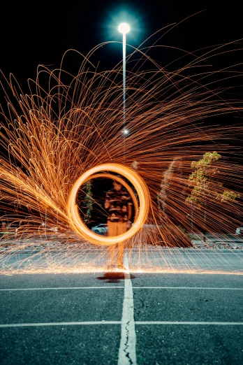 a person holding a large circular sparkler while walking across a street