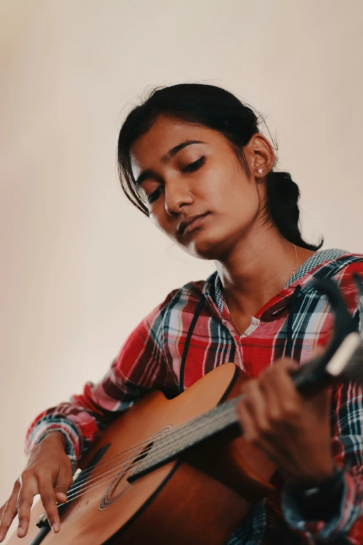 a person playing a guitar with their eyes closed