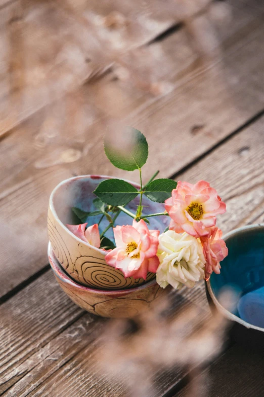 two flower pot sitting on top of a wooden table
