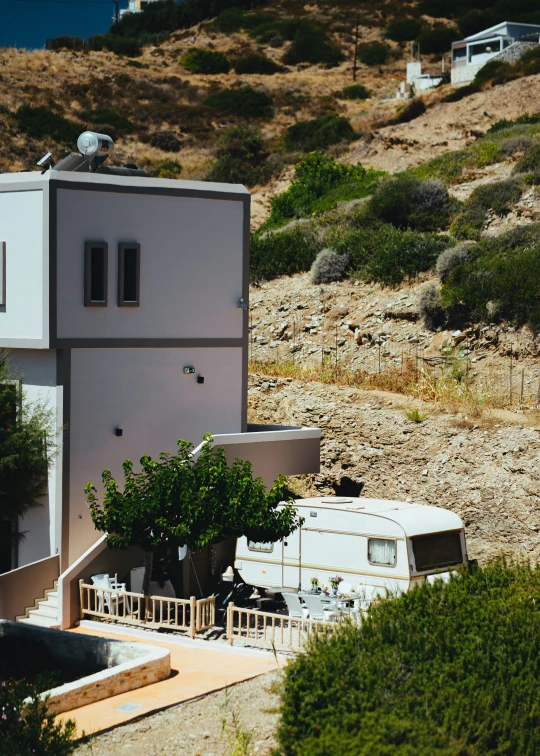 a gray house with small trees next to it